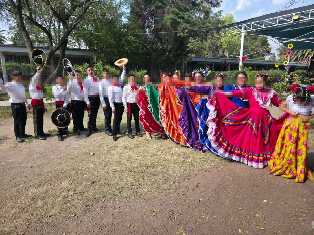 Grupo completo de alumnos charros y bailarinas en formación en el patio escolar