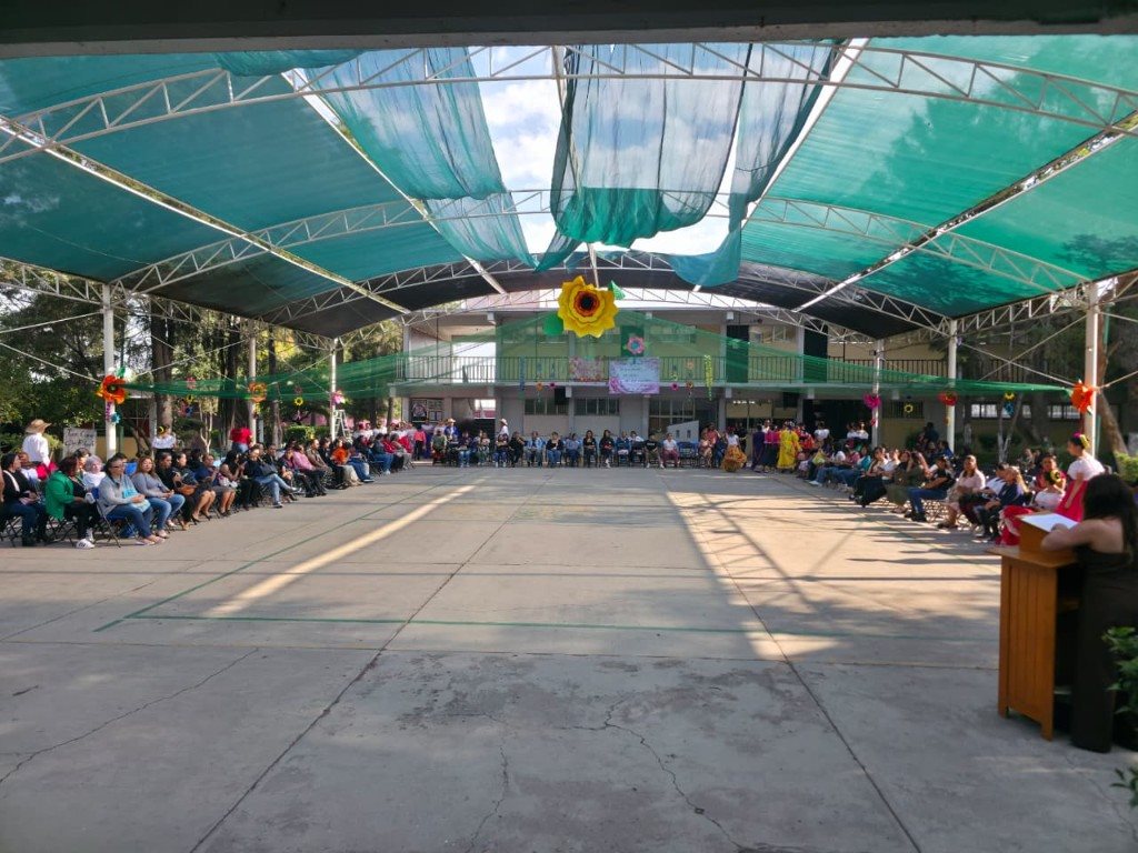 Vista general del domo escolar con decoración de girasoles y el atril listo para el evento